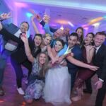 A group of people posing for a photo at a wedding.