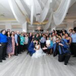 A group of people posing for a photo at a wedding.
