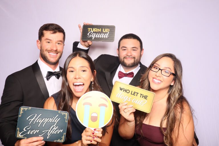 Family posing with props at a South Florida photo booth rental during a wedding