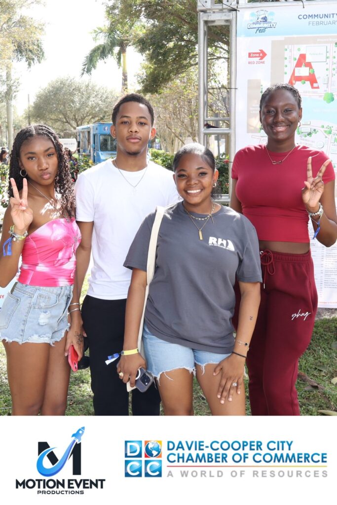 Four guests posing at a Motion photo booth at a Davie-Cooper City Chamber of Commerce community event
