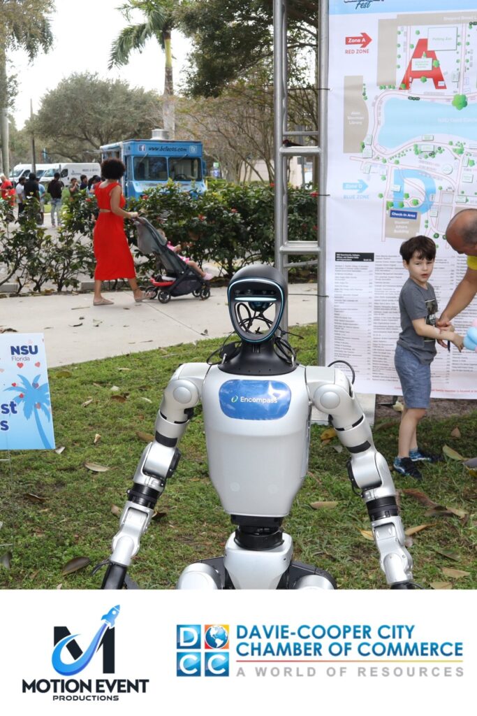 Robot mascot photographed at a Motion photo booth during a Davie-Cooper City Chamber of Commerce event