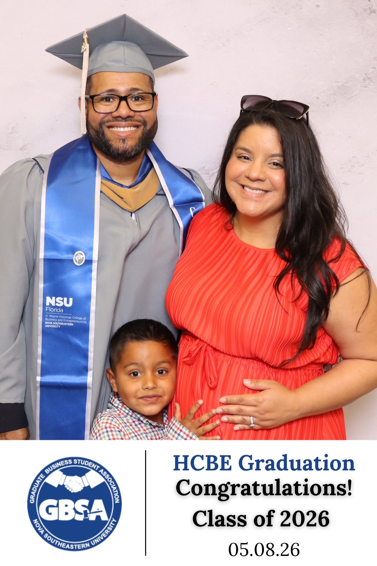 Graduate with family and a young child at a class of 2026 graduation photo booth