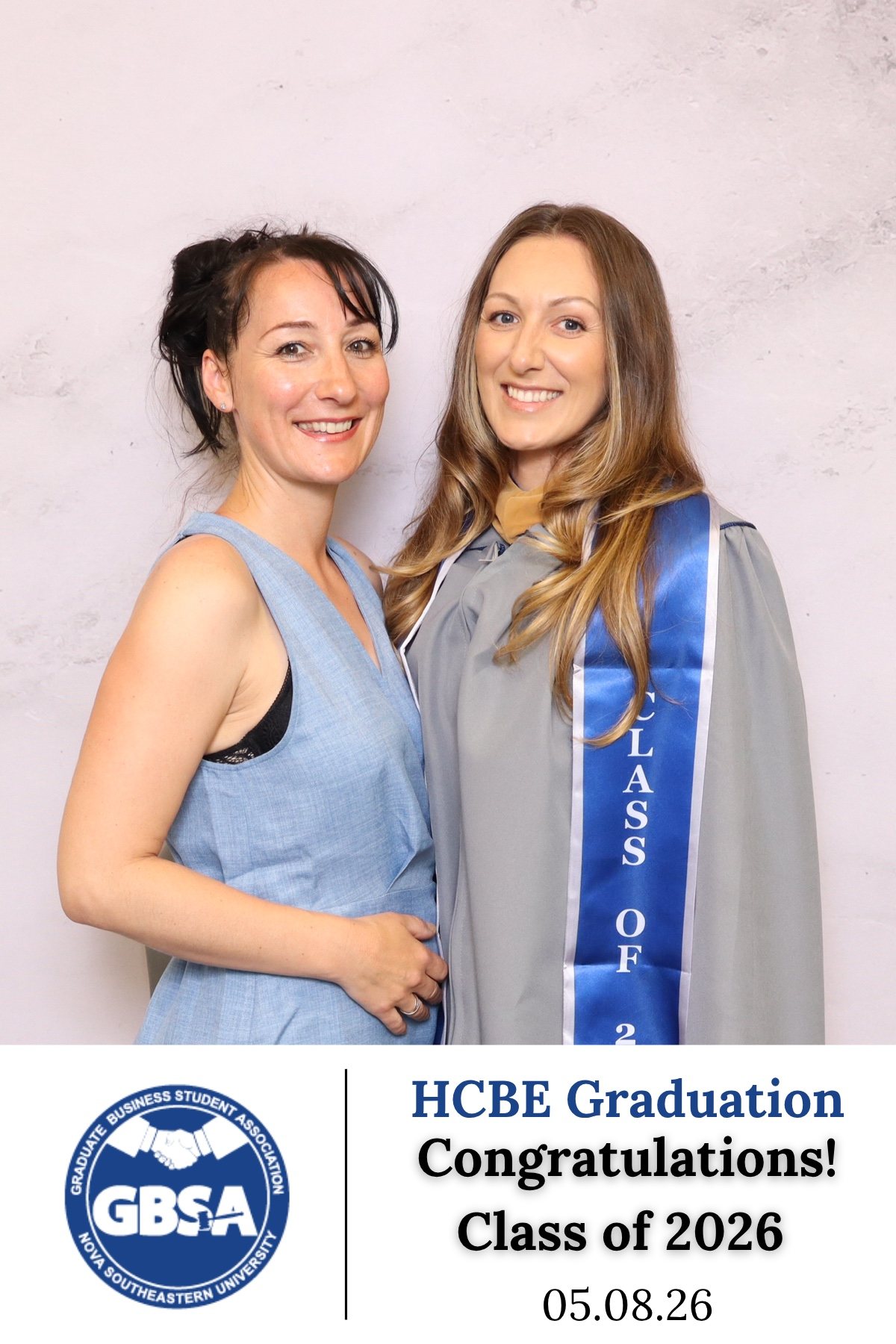 Two guests posing at a class of 2026 graduation photo booth