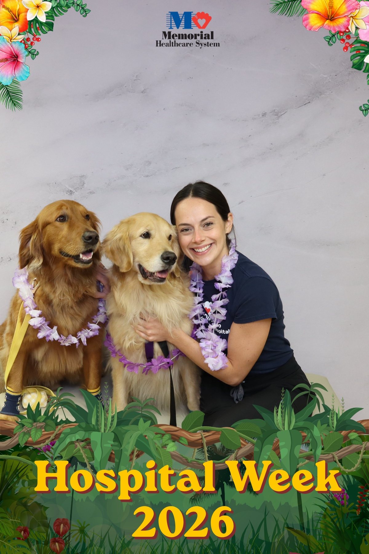 Hospital staff member with two golden retrievers at a Hospital Week photo booth