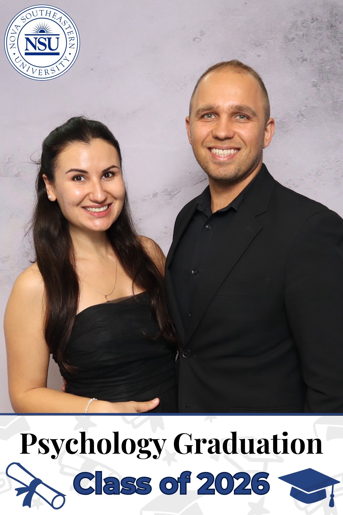 Two guests posing at a university psychology graduation photo booth in South Florida